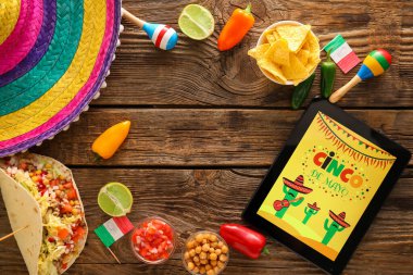 Geleneksel Meksika yemeği, sombrero, marakas ve tahta zemindeki tablet bilgisayardan yapılmış çerçeve. Cinco de Mayo (5 Mayıs) kutlamaları