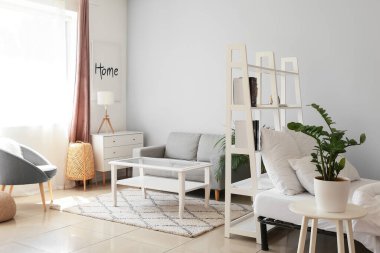 Beyaz kitaplık ve kanepeli, aydınlık yatak odasının içi.