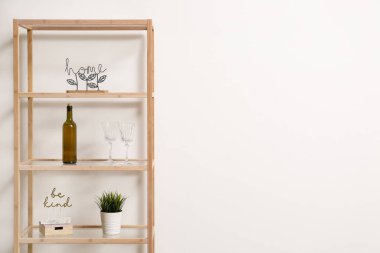 Şarabı, bardağı ve dekoru olan raf ünitesi.