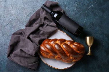 Koyu arkaplanda şarap olan geleneksel challah ekmeği. Şabat Şalom