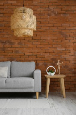 Modern oturma odasının içinde şık bir kanepe ve lamba var.