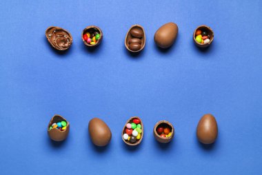 Mavi arka planda farklı dolguları olan lezzetli çikolata yumurtaları.