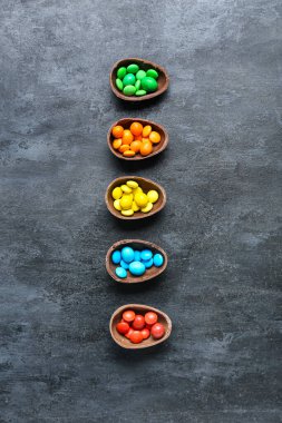 Paskalya yumurtalarının yarısı ve koyu arkaplanda farklı şekerler.