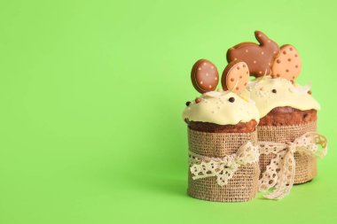 Yeşil arka planda kurabiyelerle süslenmiş lezzetli Paskalya pastaları.