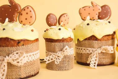 Bej arka planda kurabiyelerle süslenmiş lezzetli Paskalya pastaları.