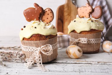 Kurabiyelerle süslenmiş lezzetli Paskalya pastaları ve arka planda söğüt dalları.