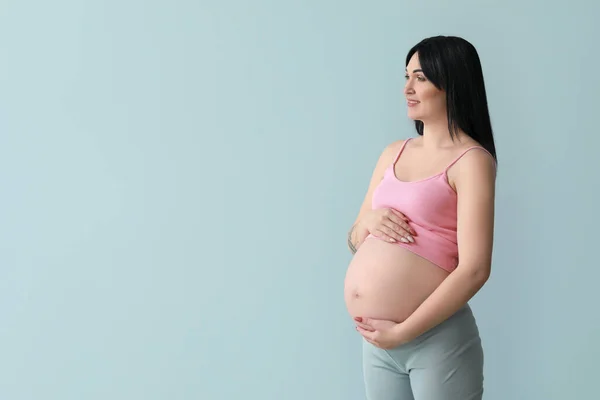 灰色の背景に妊娠中の若い女性 — ストック写真
