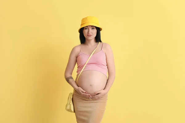 黄色の背景にスタイリッシュな妊娠中の若い女性 — ストック写真