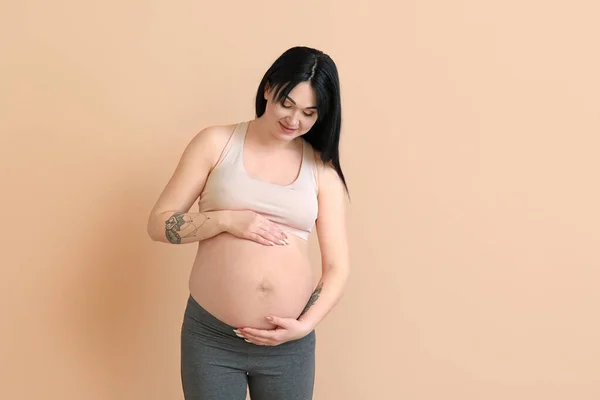 Беременная Молодая Женщина Бежевом Фоне — стоковое фото