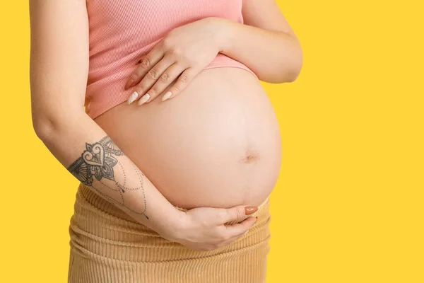 黄色の背景に妊娠中の若い女性 — ストック写真