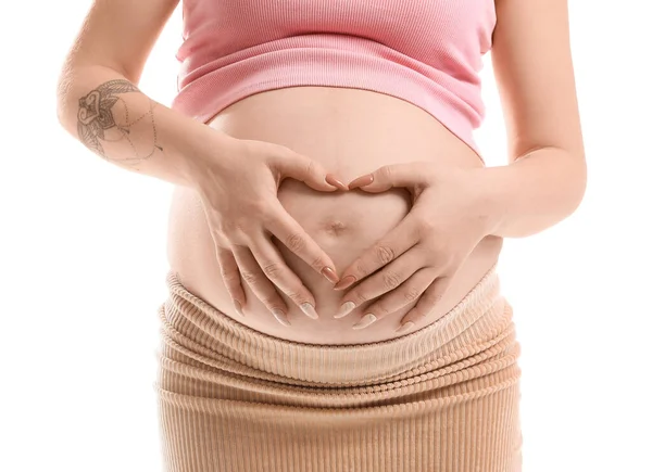 妊娠中の女性作る心形とともに彼女の手上の腹に白を背景に クローズアップ — ストック写真