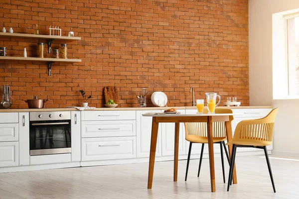 Interieur Van Moderne Keuken Met Eettafel Witte Toonbanken Bakstenen Muur — Stockfoto