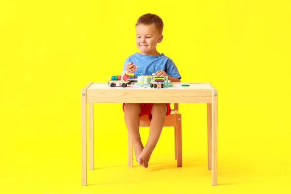 Lindo Niño Jugando Con Bloques Construcción Mesa Sobre Fondo Amarillo —  Fotos de Stock