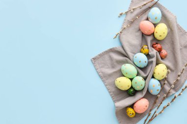 Mavi arka planda boyanmış Paskalya yumurtaları ve söğüt dalları