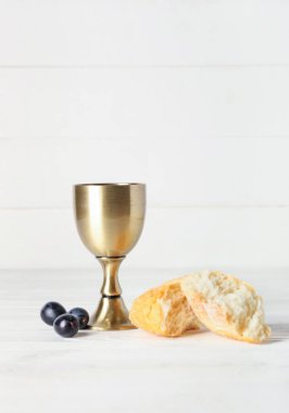 Beyaz ahşap arka planda ekmeği olan bir bardak şarap.