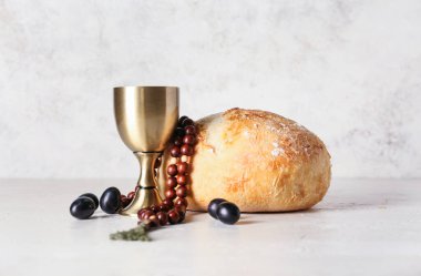 Ekmekli bir bardak şarap ve arka planda tespih.