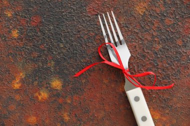 Grunge arka planında kırmızı kurdeleli çatal