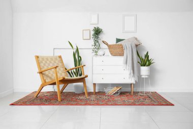 Koltuğu, çekmecesi ve klasik halısı olan rahat bir oturma odası.