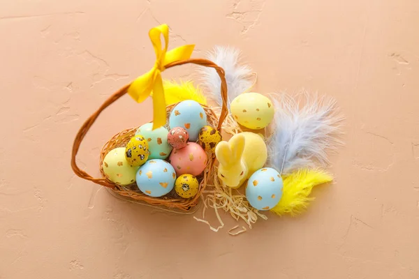 有彩绘复活节彩蛋 羽毛和米色背景兔子的篮子 — 图库照片