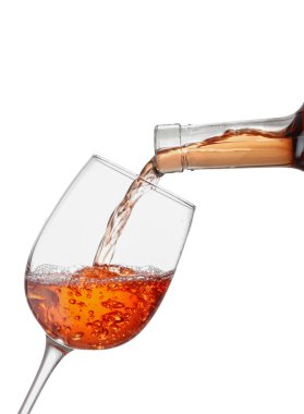 Beyaz arka planda kadehe lezzetli şarap dökülüyor.