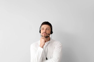 Işık arka planında çağrı merkezinin düşünceli danışmanı.