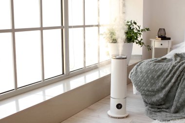 Yatak odasındaki pencerenin yanında modern nemlendirici