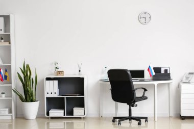 Işık duvarının yanındaki masada Rus bayrağı olan modern ofis.