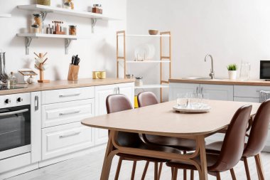 Modern mutfakta bir bardak suyla yemek masası.