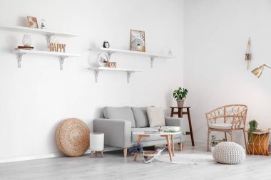 Gri kanepeli ve hasır koltuklu aydınlık oturma odasının içi.