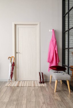 Yağmurluk ve şemsiyeli modern koridorun içi