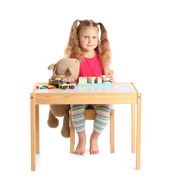 可爱的小女孩在白底桌旁玩积木 — 图库照片