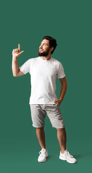 Schöner Mann Weißen Shirt Zeigt Auf Etwas Auf Grünem Hintergrund — Stockfoto