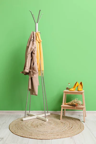 緑の壁の近くのジャケットやスカーフでハンガー — ストック写真