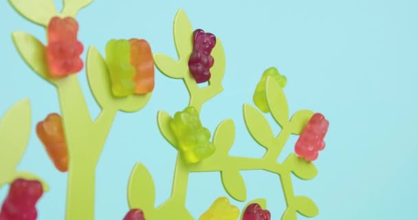 Dekorativer Baum Mit Vielen Gummibärchen Auf Farbigem Hintergrund — Stockvideo