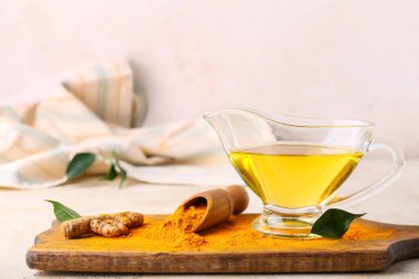 Yağlı sos teknesi, zerdeçal kökü ve hafif arka planda pudra ile kepçe.