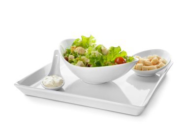 Beyaz arka planda izole edilmiş bir kase lezzetli vegan Sezar salatası.