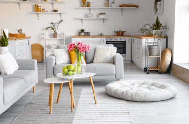 Taze elmalı sepet ve laleli vazo.