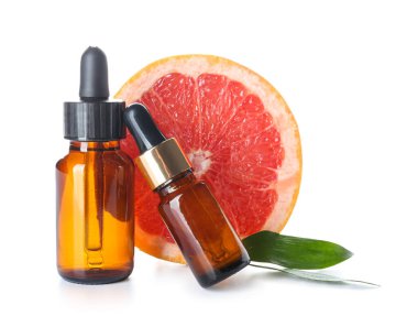 Beyaz arka planda greyfurt yağı şişeleri