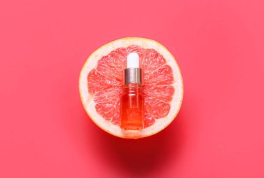 Temel yağlı bir şişe ve arka planda yarım greyfurt.