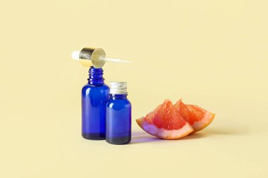 Gerekli yağlı şişeler ve arkaplanda greyfurt parçaları