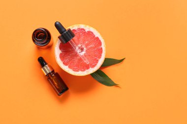 Temel yağlı şişeler ve arka planda yarım greyfurt.