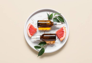 Renkli arka planda greyfurt yağı şişeleriyle kaplanmış.