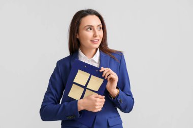 Not kağıdına ışıklı arka planda yapışkan kağıtları olan genç kadın.