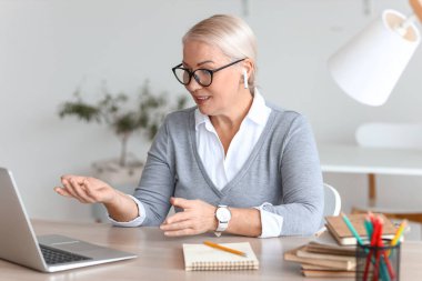 Bayan öğretmen çevrimiçi ders veriyor.