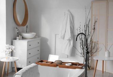 Hafif banyoda küvette tablet bilgisayarlı tepsi.