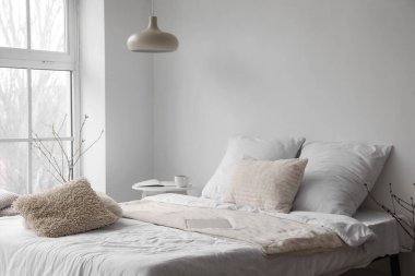 Yatağın yanındaki beyaz duvarın yanındaki modern dizüstü bilgisayar.