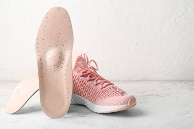 Açık arkaplanda ortopedik taban ve ayakkabı