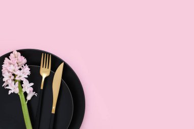 Basit masa ayarları ve pembe arkaplanda sümbül çiçekleri.