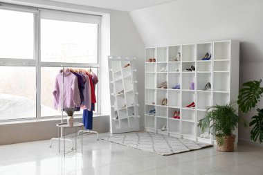 Giysileri, ayakkabıları, rafları ve aynaları soyunma odasına dizin.