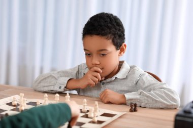Kulüpte turnuvada satranç oynayan küçük Afro-Amerikalı çocuk.